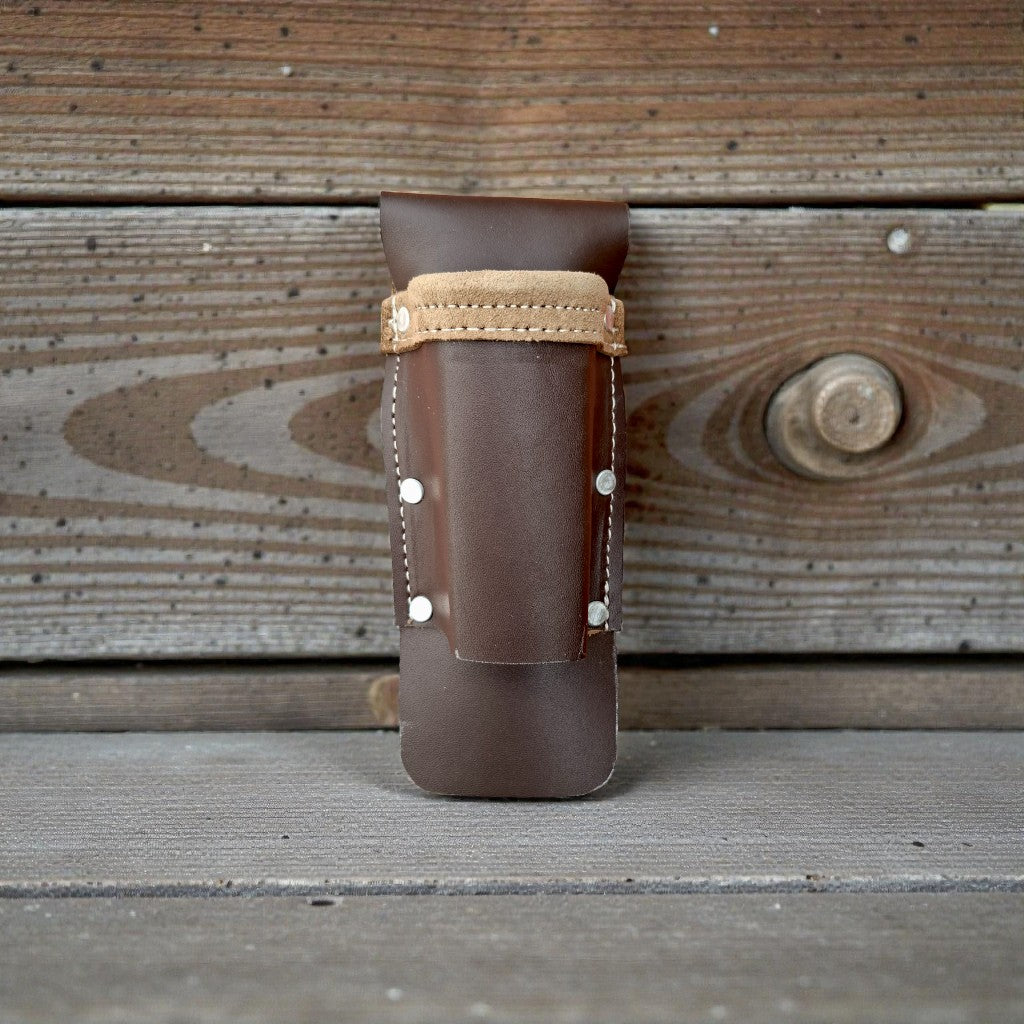 Brown leather holster with beige strap on a wooden background